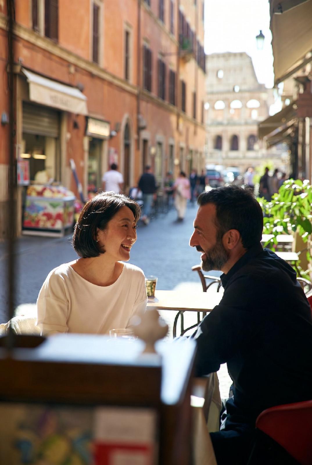 ローマのカフェでコーヒーを楽しむ日本人女性とイタリア人男性